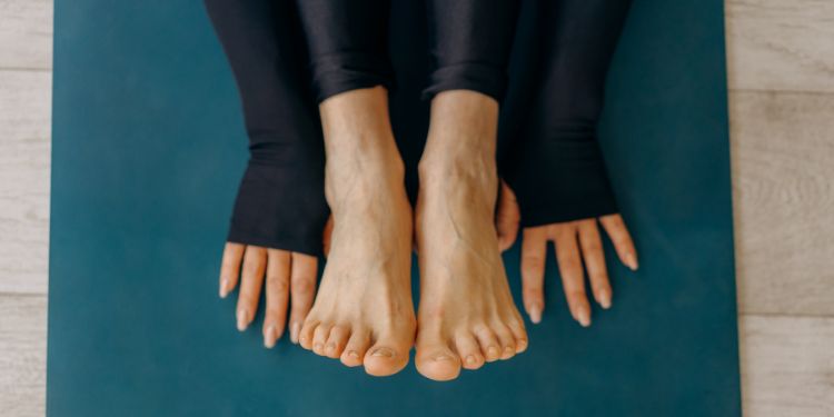 yoga feet min hands and feet on a yoga mat